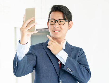 Young asian business men portrait in suit  holding smartphone against white background