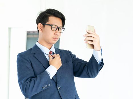 Young asian business men portrait in suit  holding smartphone against white background