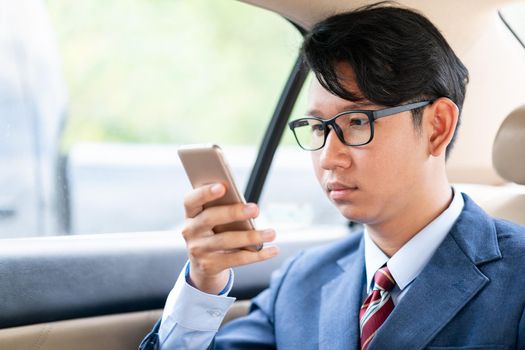 Young asian business men portrait in suit  talking on the phone in car