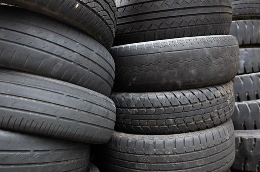 old used car tires stacked in piles in the daytime