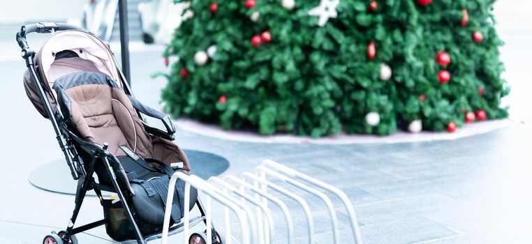 Empty baby stroller parked at outdoor area of shopping mall. Child pram stroller for baby transportation to travel with family. Baby carriage. Activity outside home with child. Abandoned child pram.