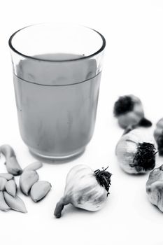 Fresh organic Garlic juice isolated on white along with fresh garlic cloves and garlic bulbs.