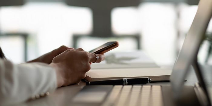 Close up woman use of smart phone on workplace at office,