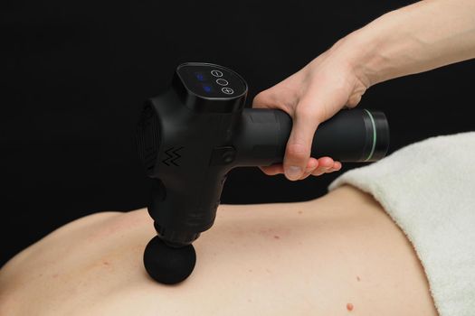 Hardware back massage. The percussion apparatus. The patient is lying on the massage couch. High quality photo