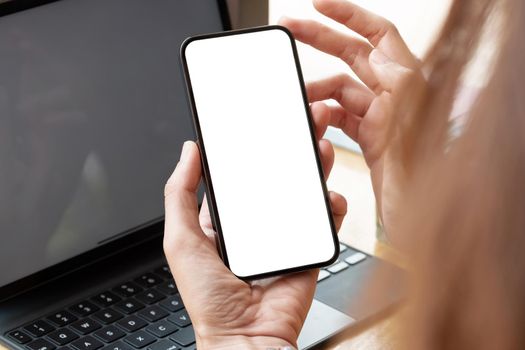 Top view of woman hand using smartphone with blank white screen.