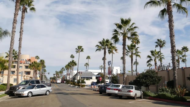 Oceanside, California USA - 27 Jan 2020: Palm trees on typical american street, pacific coast tropical resort. Auto transport on road, generic view of city. Sunny summer day in small town on route 101