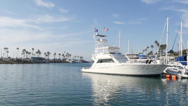 Oceanside, California USA - 27 Jan 2020: Waterfront harbor fisherman village, luxury yachts sailboats floating, marina harbour quay. Sail boat masts, nautical vessels anchored or moored in port.