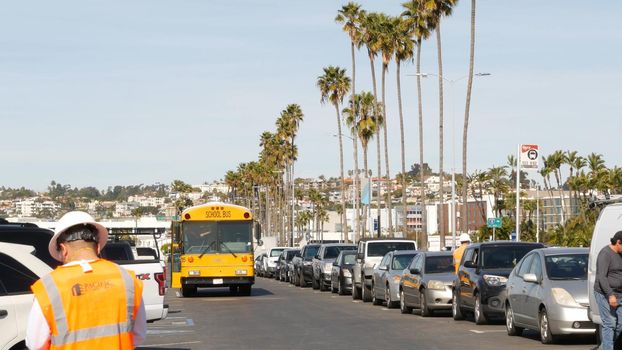 San Diego, California USA - 31 Jan 2020: American yellow school bus, street in downtown. Schoolbus shuttle on road, city near Los Angeles. Education transportation infrastructure.