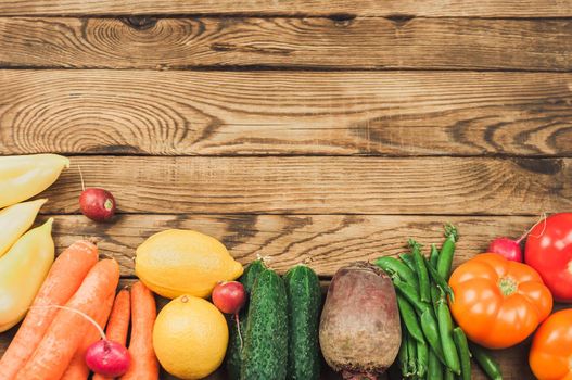 Flat lay of seasonal fruits, vegetables and herbs. Summer food concept. Healthy life and vegetarian, vegan, diet, clean food ingredients. Place for text. Food on a dark wooden background.