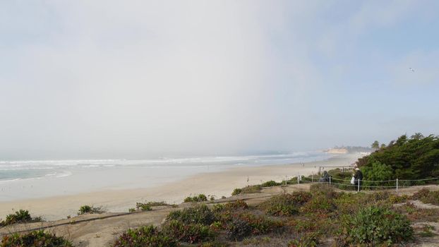 Del Mar, California USA - 23 Jan 2020: Pacific ocean beach view from above. Vista point in Seagrove park. Fog cloud, misty haze weather. June gloom, marine layer panoramic shot. Sea coast milky brume.
