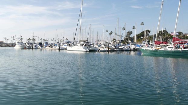 Oceanside, California USA - 27 Jan 2020: Waterfront harbor fisherman village, luxury yachts sailboats floating, marina harbour quay. Sail boat masts, nautical vessels anchored or moored in port.