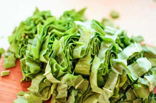 Fresh organic sorrel,plant spinach heap on wooden table for spring green vegetables soup and salad.Raw sorrel leaves top view green vegetable background.Spring green vegetables,sorrel spinach