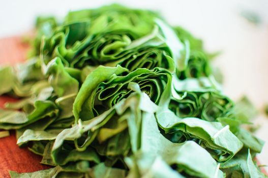 Fresh organic sorrel,plant spinach heap on wooden table for spring green vegetables soup and salad.Raw sorrel leaves top view green vegetable background.Spring green vegetables,sorrel spinach