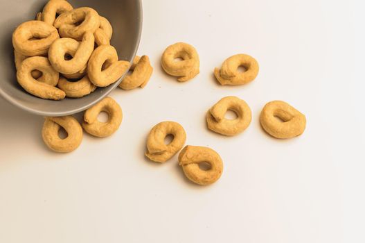 Taralli - a traditional Italian appetizer similar to drying or bagels, typical for the cuisine of Sicily and Calabria. Bagel on a white plate in a bowl.