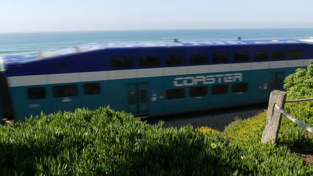 Del Mar, California USA - 23 Jan 2020: Coaster train, travel along pacific ocean beach. Passenger railroad, public transit. Express rapid intercity double decker blue commuter. NCTD railway transport.