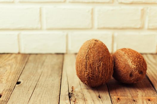 tropical coconut fruits on a wooden background in rustic style. Template for design. Copy space.