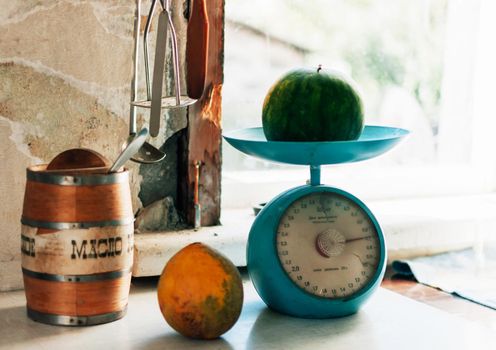 Autumn still life with melon and watermelon on a scale and on a wooden white table. Weighing the crop. Autumn harvest concept. Happy Thanksgiving. Selective focus. Horizontal orientation.