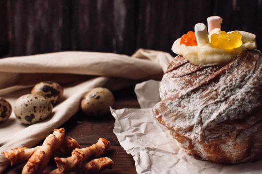 Stylish Easter cake with marshmallows and jelly bears on parchment paper on a rustic wooden background. Seasonal greetings of happy Easter. selective focus. modern happy easter image