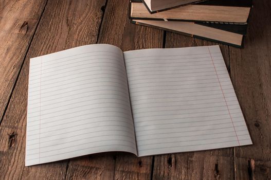 Back to school, the concept of raising children. Day of knowledge. Notebook in line on a wooden table with space for text. Save space. Rustic and vintage toning.