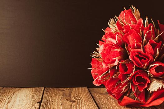 Back to school, the concept of parenting. Day of knowledge.A bouquet of roses against the background of a black school board.Education concept.Copy space. Rustic and vintage toning.