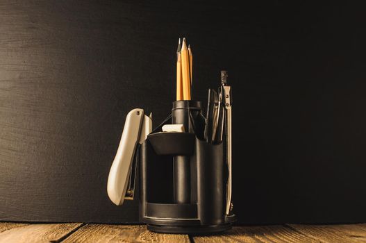 Back to school, the concept of parenting. An assortment of consumables, stands for pens and pencils, an eraser, stationery knives, compasses.Education concept.Copy space. Rustic and vintage toning.