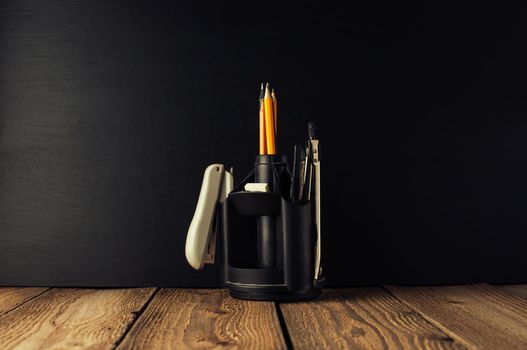 Back to school, the concept of parenting. An assortment of consumables, stands for pens and pencils, an eraser, stationery knives, compasses.Education concept.Copy space. Rustic and vintage toning.