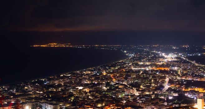 Aerial night view of the city of Terracina, Italy, by the Mediterranean sea.