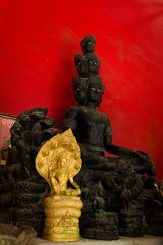 Statue of a buddhist asura, a demigod with many faces, on display in a temple in Phuket, Thailand.