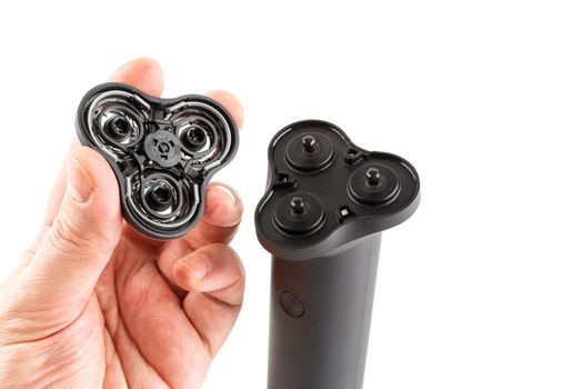 caucasican hand holding three razor head of black electric shaver - isolated.
