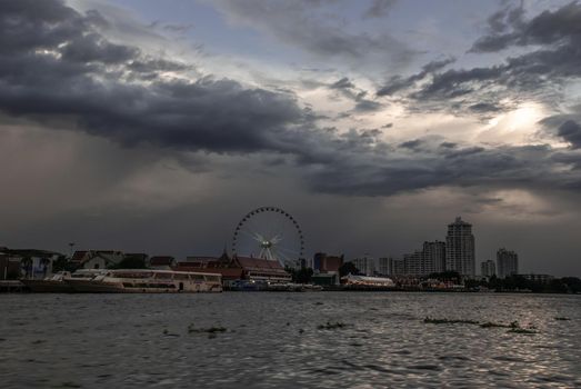 Bangkok, thailand 21 Jul, 2019 : The Chao Phraya River view of the Wat Ratcha Singkhon with Asiatique Ferris Wheel and Blue Sky at the Background.