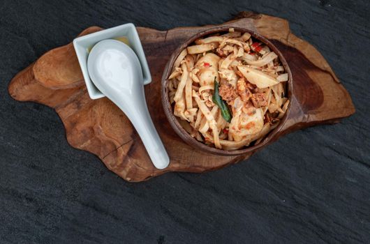 Thai food, Spicy stir fried bamboo shoot with fish ball in a wooden bowl. Top view.