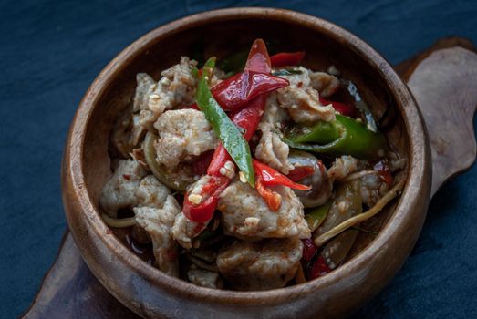 Thai Spicy food, Spicy stir fried fish balls and thai herbs vegetables in wooden bowl : in Thai language called "Pad Cha " Oblique view from the top.