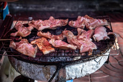 Many Grilled pork ears on a steel grill on a charcoal stove. (Thai style food), Selective focus.