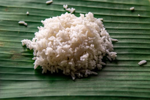 White rice is cooked rice by steaming or boiling on served on a banana leaf in Thai restaurant that is staple food in Thailand, Selective focus.