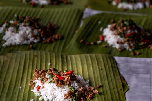Rice topped with Stir fried Thai basil with minced pork (Pad Ka Prao Moo) on served on a banana leaf, A world renowned delicacy from Thailand, Selective focus.