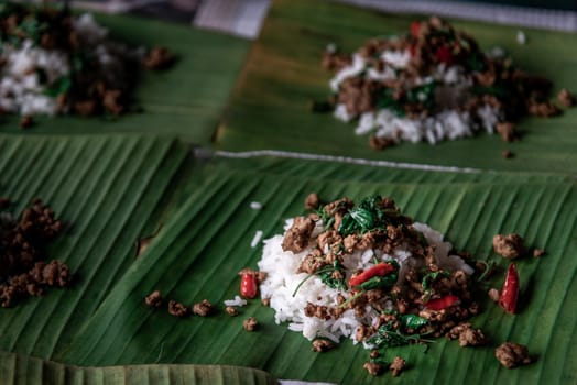 Rice topped with Stir fried Thai basil with minced pork (Pad Ka Prao Moo) on served on a banana leaf, A world renowned delicacy from Thailand, Selective focus.