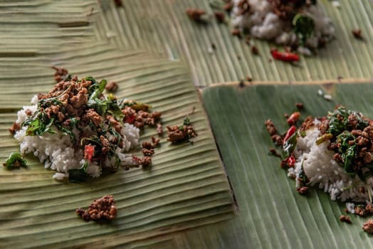 Rice topped with Stir fried Thai basil with minced pork (Pad Ka Prao Moo) on served on a banana leaf, A world renowned delicacy from Thailand, Selective focus.