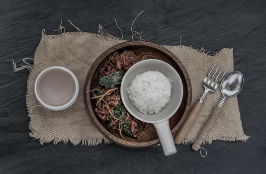 Thai Spicy food, Spicy Stir Fried Deep Fish Fillet with Herbs vegetables served with steamed rice in wooden bowl : in Thai language called "Pad Cha " Top view, Selective focus.