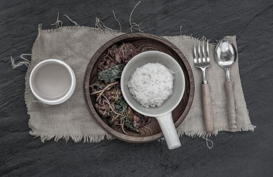 Thai Spicy food, Spicy Stir Fried Deep Fish Fillet with Herbs vegetables served with steamed rice in wooden bowl : in Thai language called "Pad Cha " Top view, Selective focus.