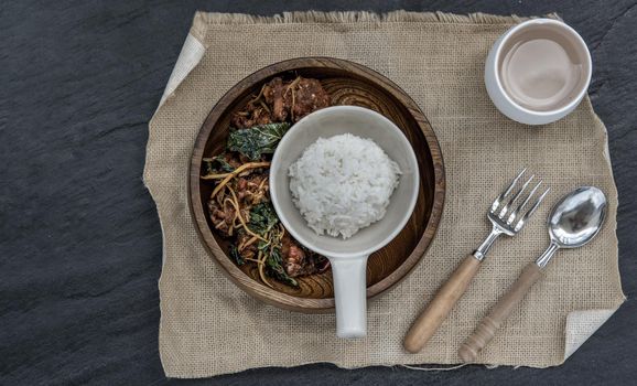 Thai Spicy food, Spicy Stir Fried Deep Fish Fillet with Herbs vegetables served with steamed rice in wooden bowl : in Thai language called "Pad Cha " Top view, Selective focus.