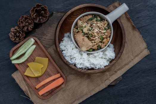 Thai food, Stir fried egg tofu with spring onion with Herbs vegetables served with steamed rice in wooden bowl, view from above.