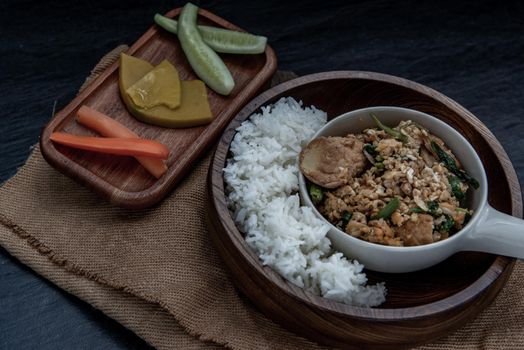 Thai food, Stir fried egg tofu with spring onion with Herbs vegetables served with steamed rice in wooden bowl, Oblique view from the top.