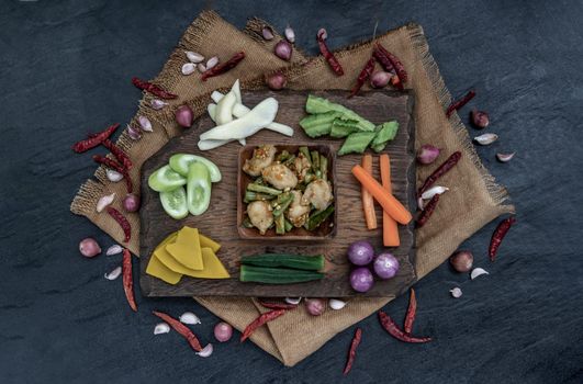 Thai food, Stir Fried fish ball with Red Curry Paste and long bean with the ingredient and fresh vegetables on wood background, view from above.