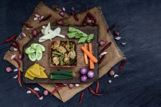 Thai food, Stir Fried fish ball with Red Curry Paste and long bean with the ingredient and fresh vegetables on wood background, view from above.
