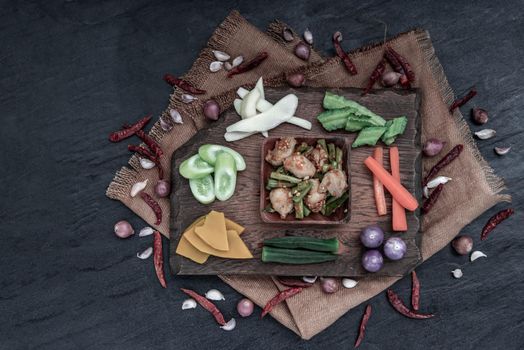 Thai food, Stir Fried fish ball with Red Curry Paste and long bean with the ingredient and fresh vegetables on wood background, view from above.