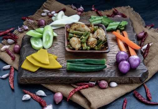 Thai food, Stir Fried fish ball with Red Curry Paste and long bean with the ingredient and fresh vegetables on wood background, Oblique view from the top.