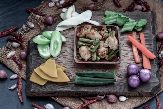 Thai food, Stir Fried fish ball with Red Curry Paste and long bean with the ingredient and fresh vegetables on wood background, Oblique view from the top.
