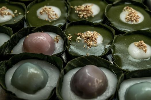 Thai Dessert Pandan Sweet Pudding (Kanom Piak Poon Bai Toey) in Sweet Coconut milk Cream with sesame seeds and Thai pudding with coconut topping, Thai dessert, Selective focus.