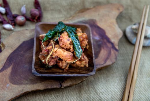 Thai Spicy food, Spicy Stir Fried Deep Fish Fillet with Herbs vegetables  in wooden bowl : in Thai language called "Pad Cha ". Oblique view from the top, Selective focus.
