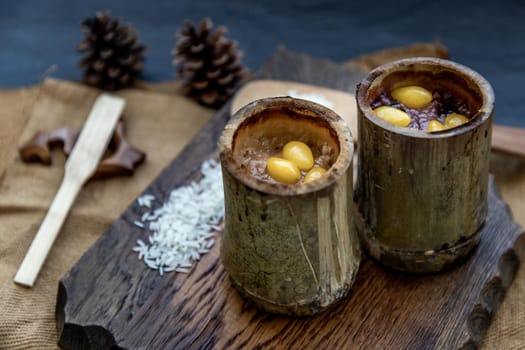 Sticky Rice Cooked with Coconut milk (Khao lam) or Glutinous rice roasted in bamboo joints on wooden, Thai dessert concept, Oblique view from the top.